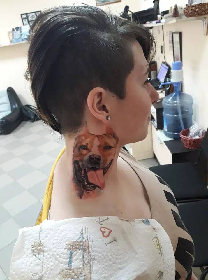 A woman with the smiling face of a Pit Bull tattoo on her neck