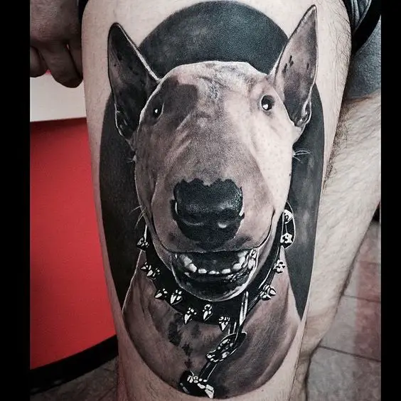 black and gray smiling face of a English Bull Terrier tattoo on the thigh of a man