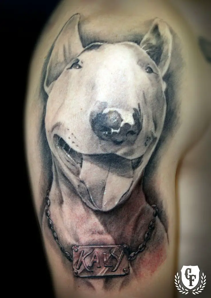 a 3D black and gray smiling English Bull Terrier tattoo on the shoulder of a man