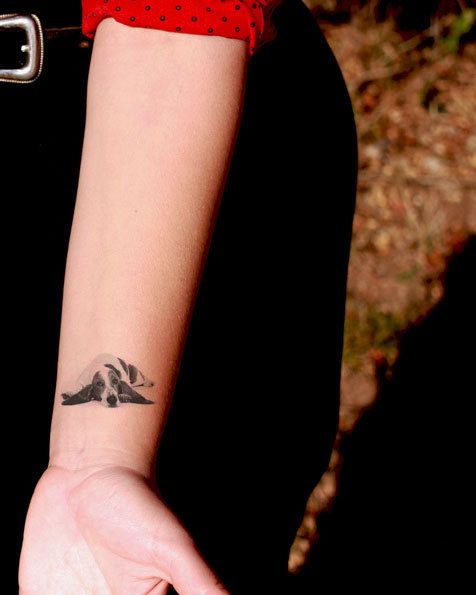 minimalist lying down Basset Hound Tattoo on the wrist