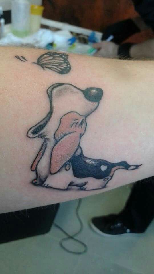 animated Basset Hound yawning while a butterfly is on top of it tattoo on the forearm