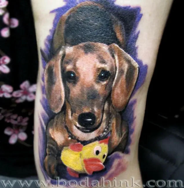 3D Dachshund lying down with its duck toy tattoo