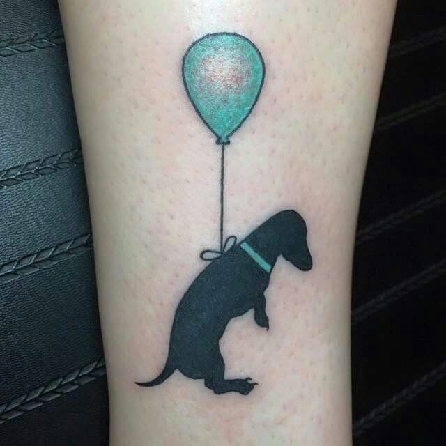 floating silhouette Dachshund by a blue green balloon tattoo on the leg