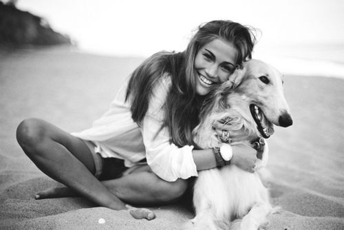 girl hugging a dog at the beach