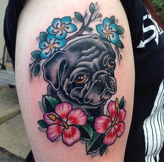 black pug with flowers around tattoo on the leg