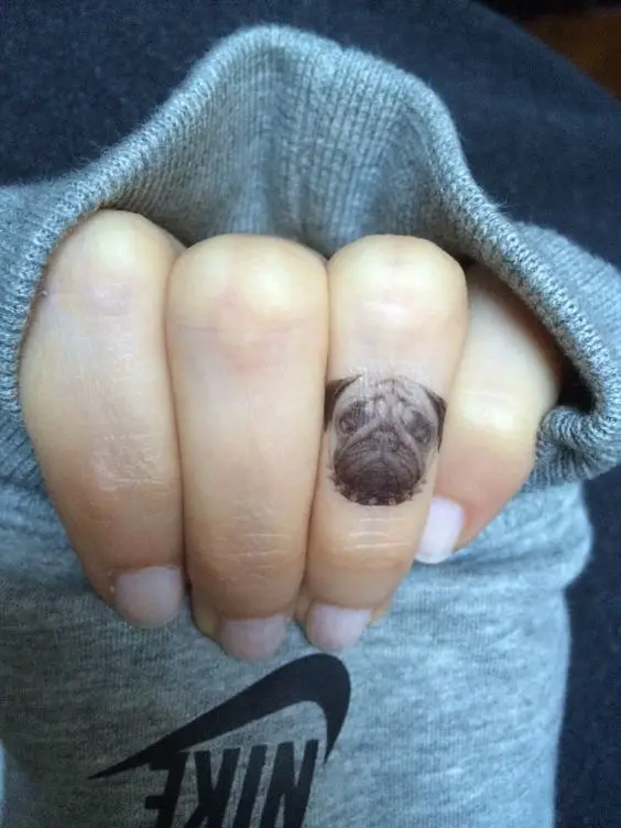 small face of Pug Tattoo on ring finger