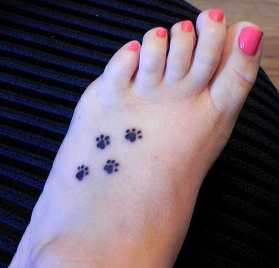 four paw prints tattoo on the foot