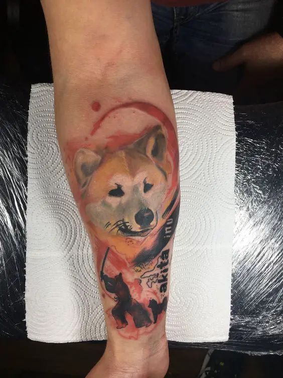 face of Akita Inu on top and a man holding sword and a Akta Inu in his feet tattoo on the forearm