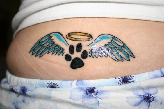 paw print with angel wings and halo tattoo on the lower back
