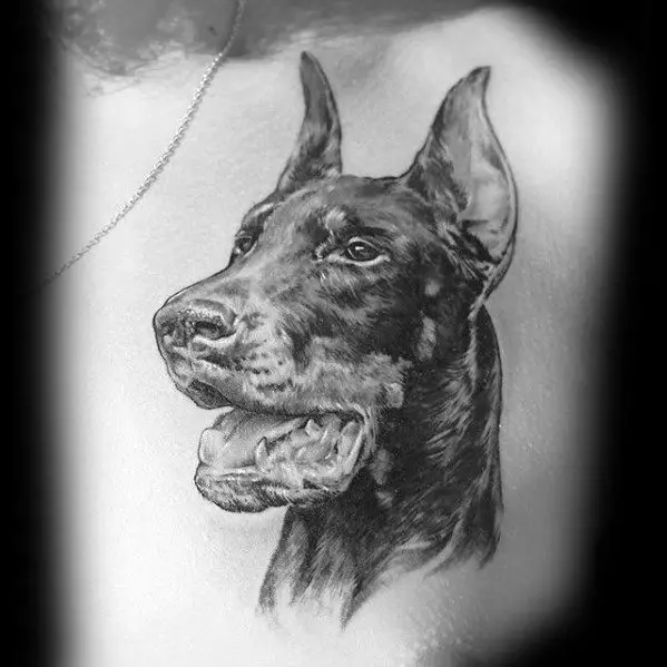 black and gray sideview head of a Doberman with its mouth open tattoo