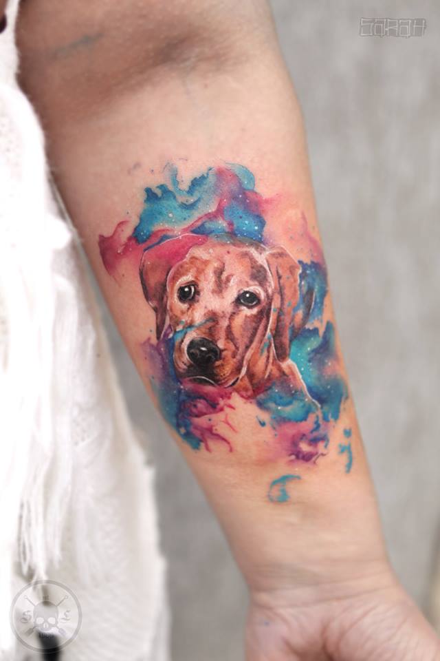 Labrador with blue and pink watercolor tattoo on the forearm