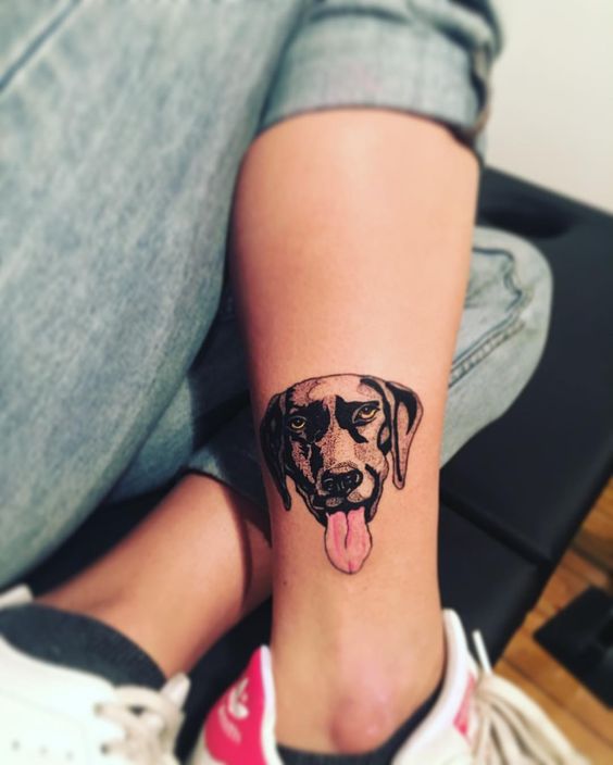 face of a brown Labrador with its tongue out tattoo on the leg