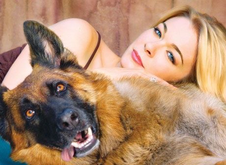 Leann Rimes leaning on top of her German Shepherd