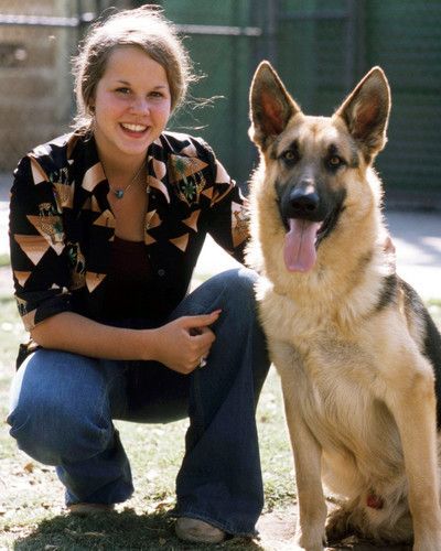 Linda Blair beside her German Shepherd sitting on the ground