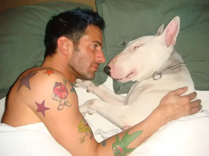 Mark Jacobs in bed with his English Bull Terrier