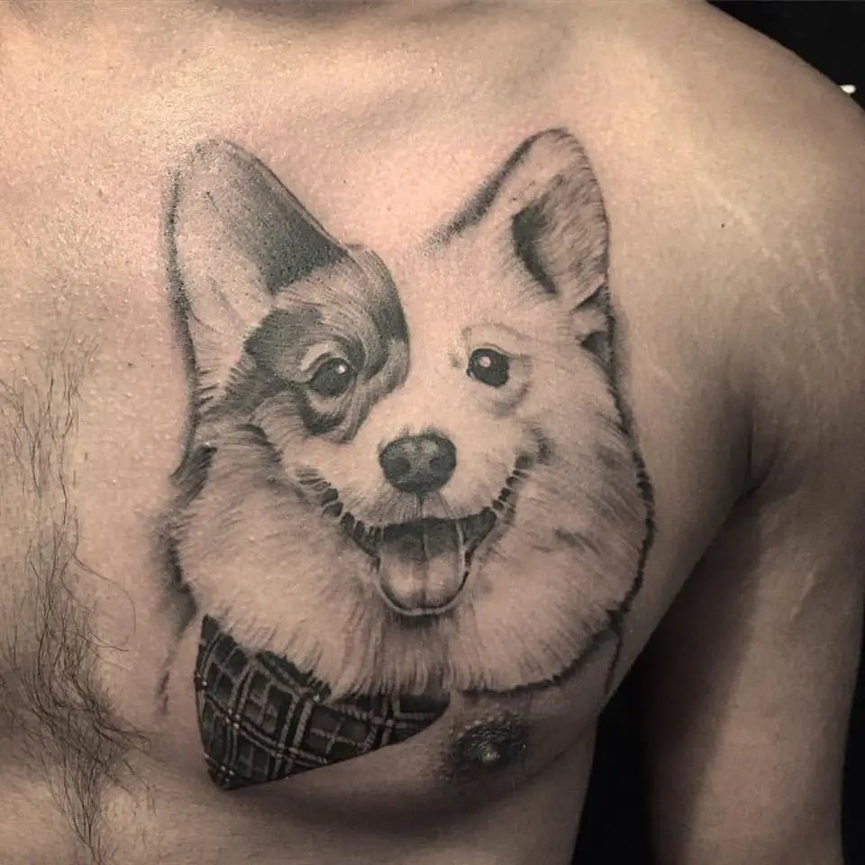 a black and gray tattoo of a corgi tatto on the chest