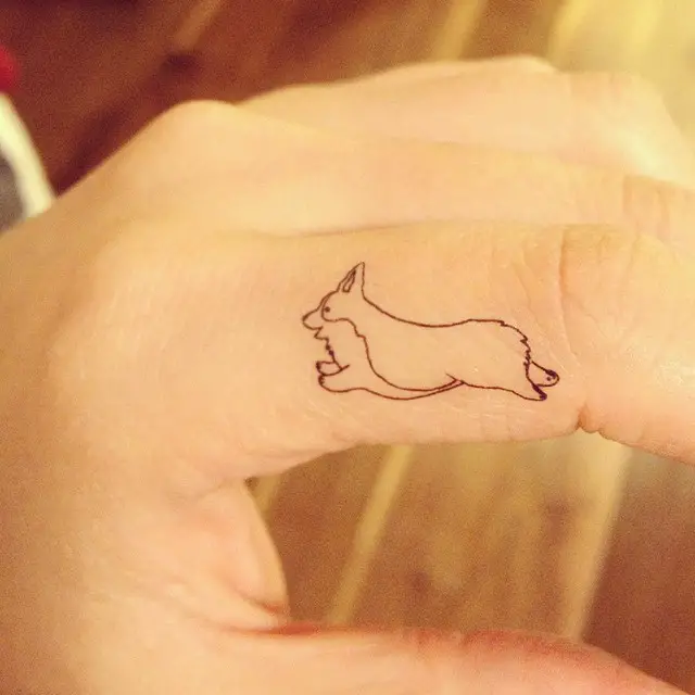 outline of a jumping corgi tattoo on the finger