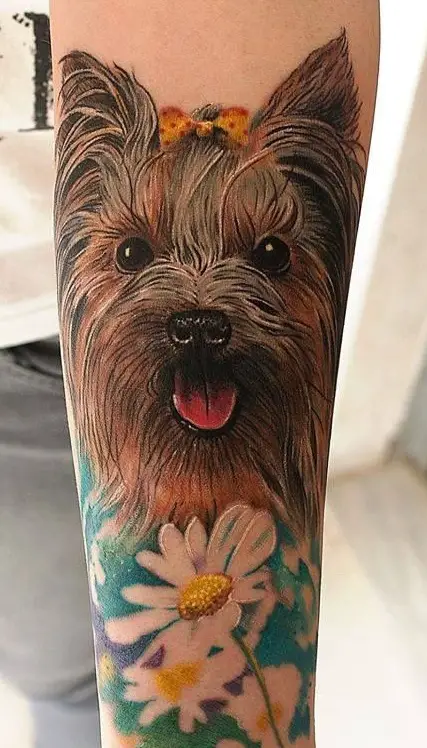 realistic yorkie with its tongue out and with white flowers in the field