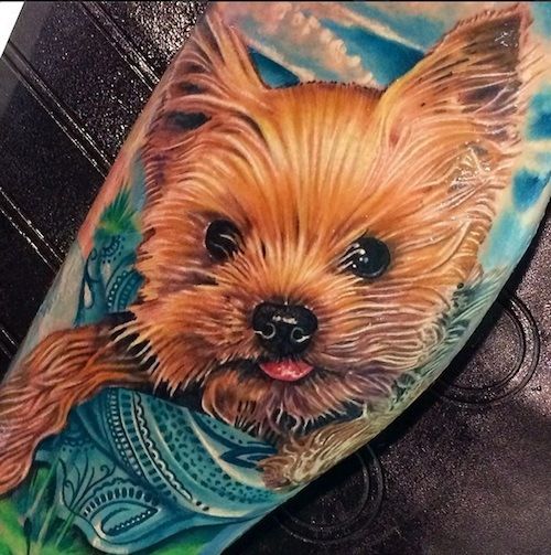 a realistic yorkie tattoo on the leg