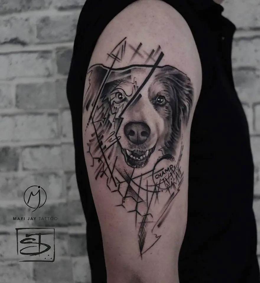 black and gray smiling face of an Australian Shepherd Dog with sketches on the side of its face tattoo on the shoulder