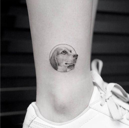 minimalist 3D face of Beagle inside a circle tattoo on the ankle