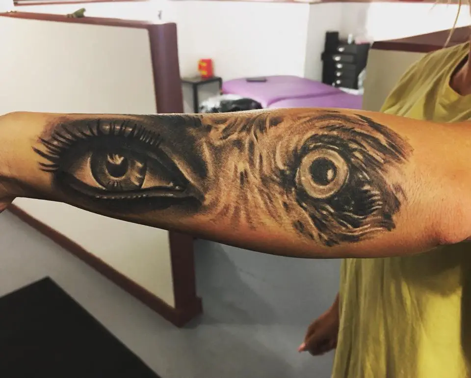 eye of a woman next to a dog tattoo on the forearm