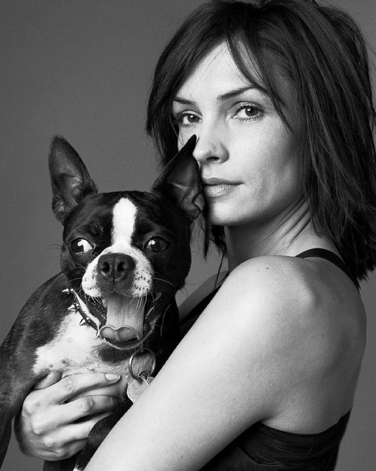 black and white photo of Famke Janssen holding her Boston Terrier