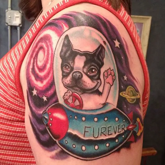 animated Boston Terrier driver a spaceship while waving its paw and smiling tattoo on the shoulder