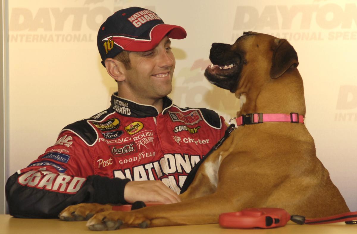 Greg Biffle smiling with his Boxer dog