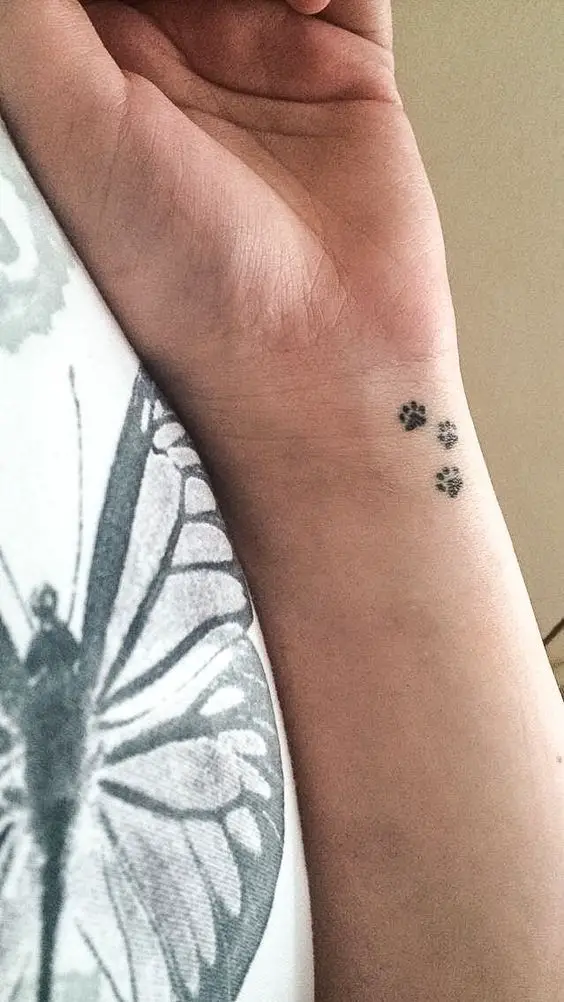 three paw prints tattoo on the wrist