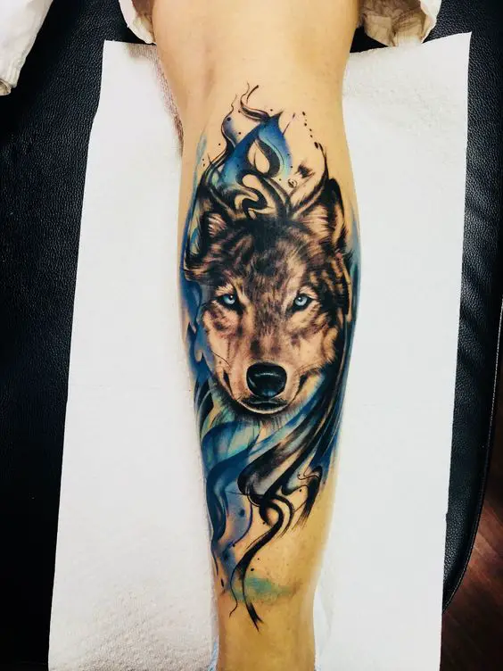 black and gray face of a Husky with blue and and with blue and black smoke tattoo on the leg