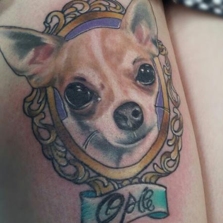 Chihuahua face on a vintage frame tattoo on the thigh