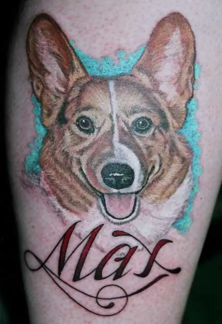 a happy face of a corgi with blue shadow and with name - Mai tattoo on the leg