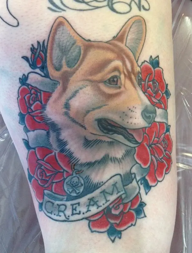 a corgi looking sideways and with red flowers tattoo on the thigh
