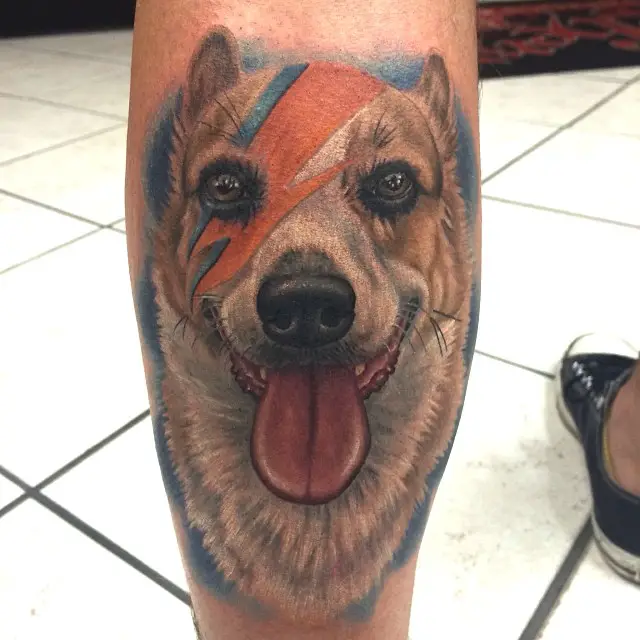 face of a corgi with its tongue out tattoo on the leg