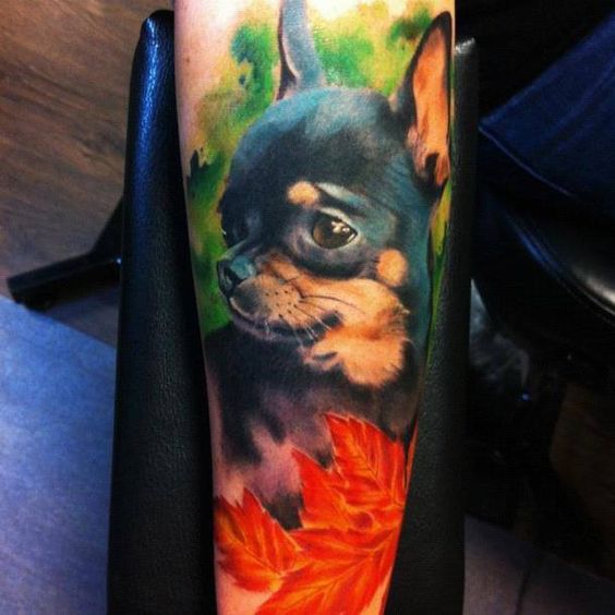 realistic Chihuahua with trees and autumn leaves tattoo on the forearm