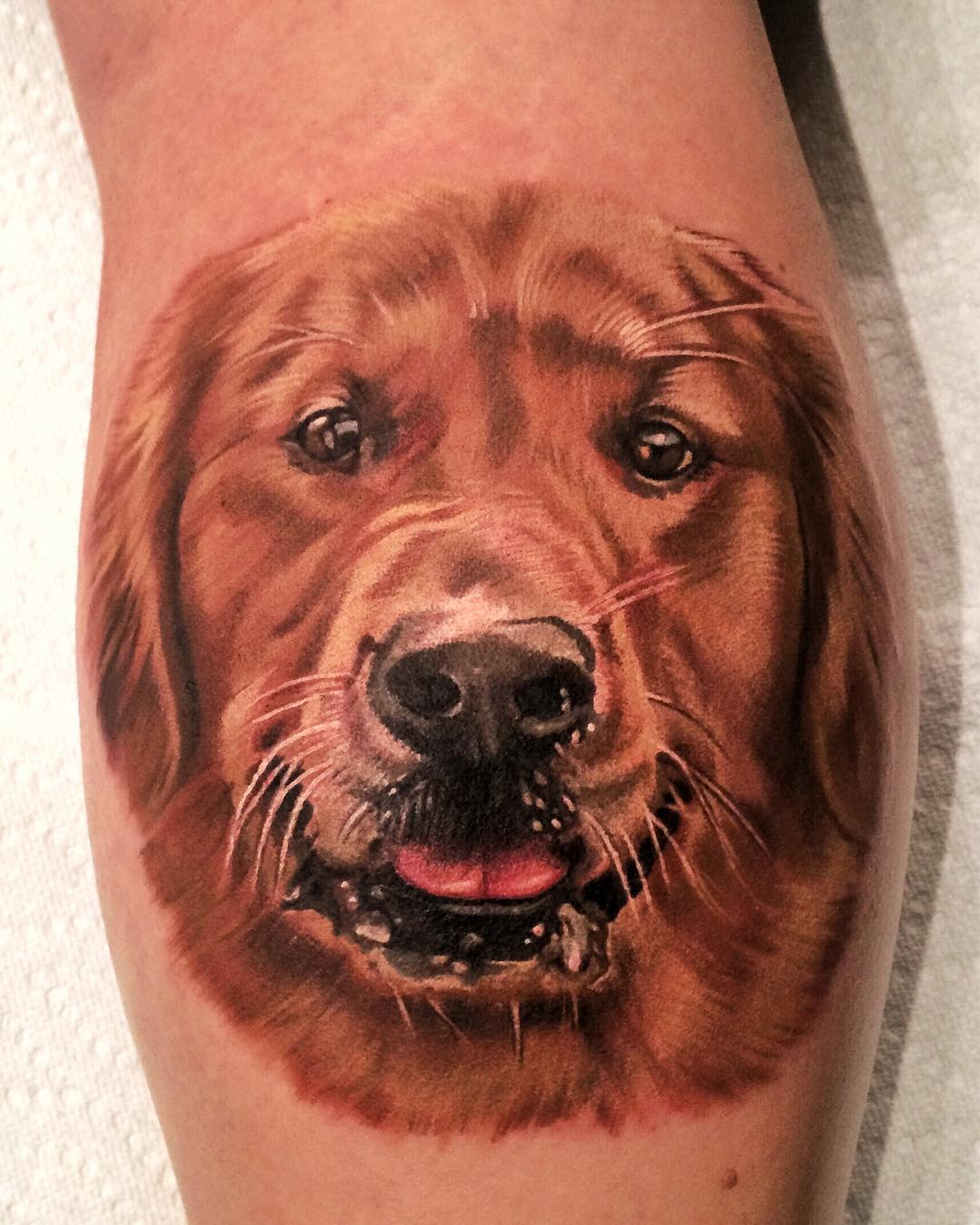 realistic smiling face of Golden Retriever Tattoo on the forearm