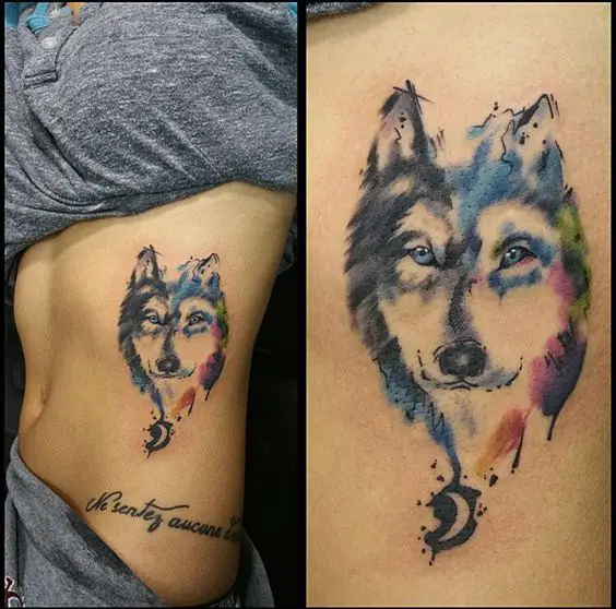 black and gray half face of a Husky and the other half is design with colorful watercolors tattoo on the side of the body