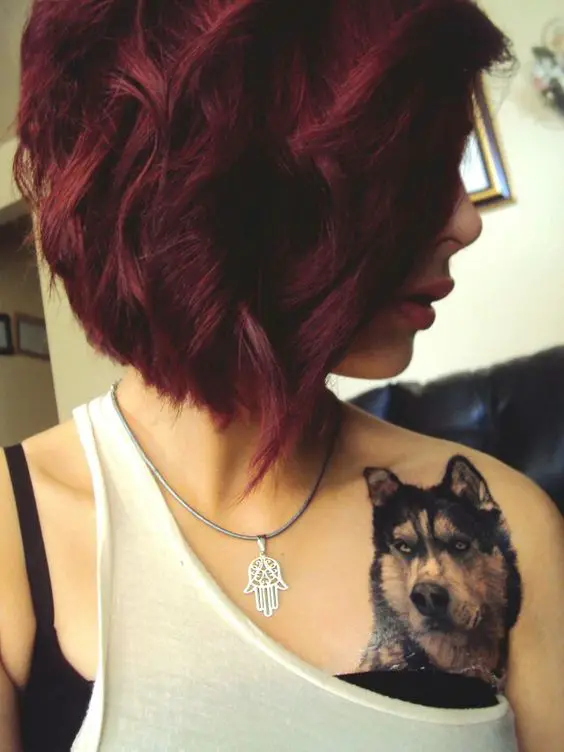 realistic black and white Husky tattoo on the chest of a woman