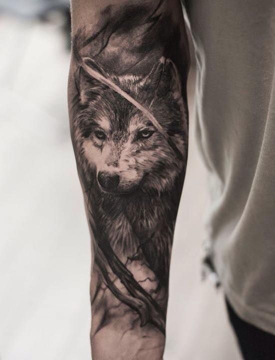 black and gray tattoo of a Husky in the woods on the forearm of a man
