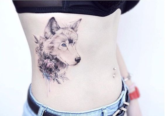 sideview head of a Husky with flowers around it neck tattoo on the side of a girls body