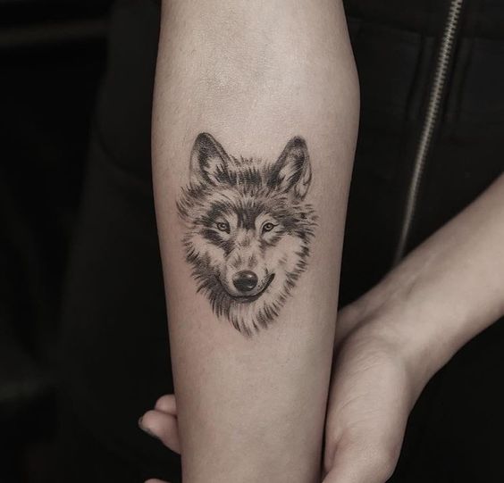 black and gray tattoo of a smiling Husky on the forearm