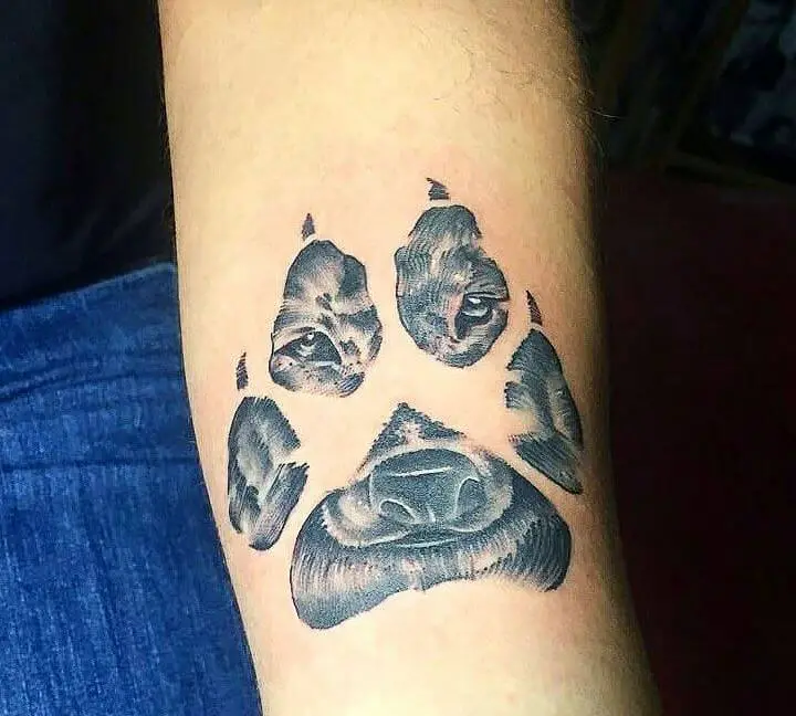 a large paw print tattoo on the forearm of the woman