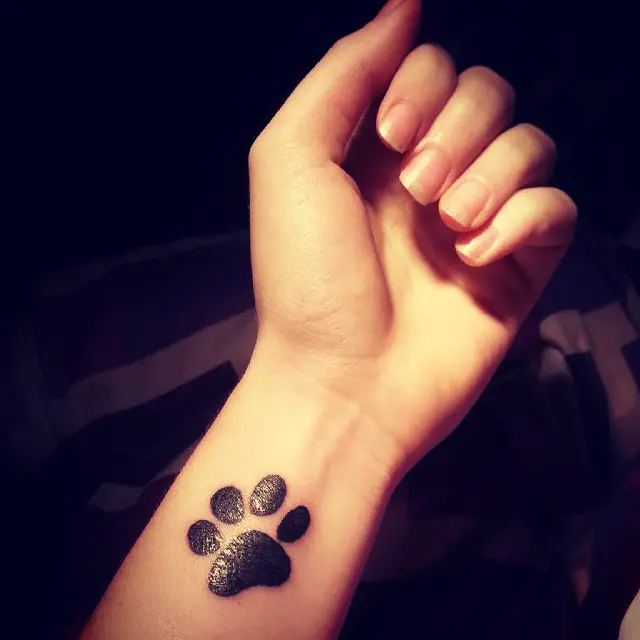 A medium sized paw print tattoo on the wrist of the woman