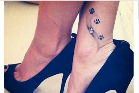 four paw print tattoo on the ankle of the woman