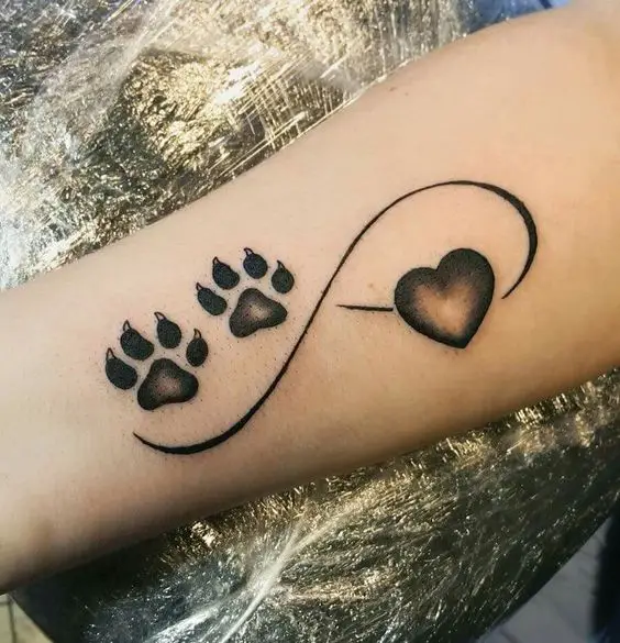 infinity sign with paw print and a heart tattoo on the forearm of the woman