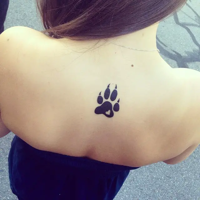 a small paw print tattoo on the back of the woman