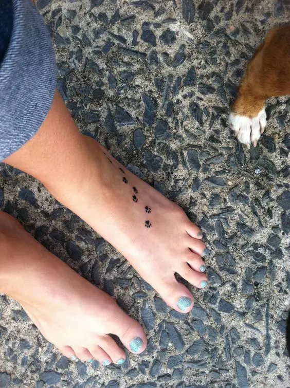 a woman with small paw print tattoo on her feet