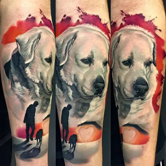 face of Labrador with a silhouette of a man walking a dog tattoo on the forearm