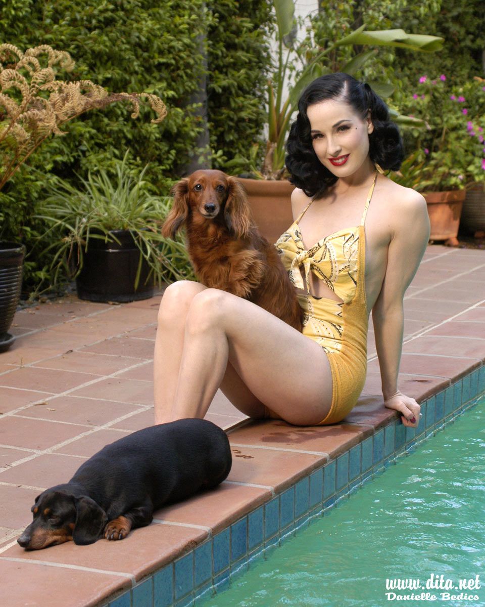Dita von Teese beside the pool with her two Dachshunds